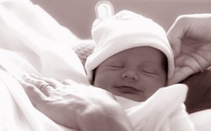 mère qui soutient la tête de son bébé qui sourit